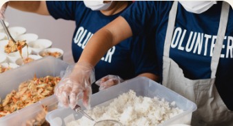 Voluntários preparando refeições para doação